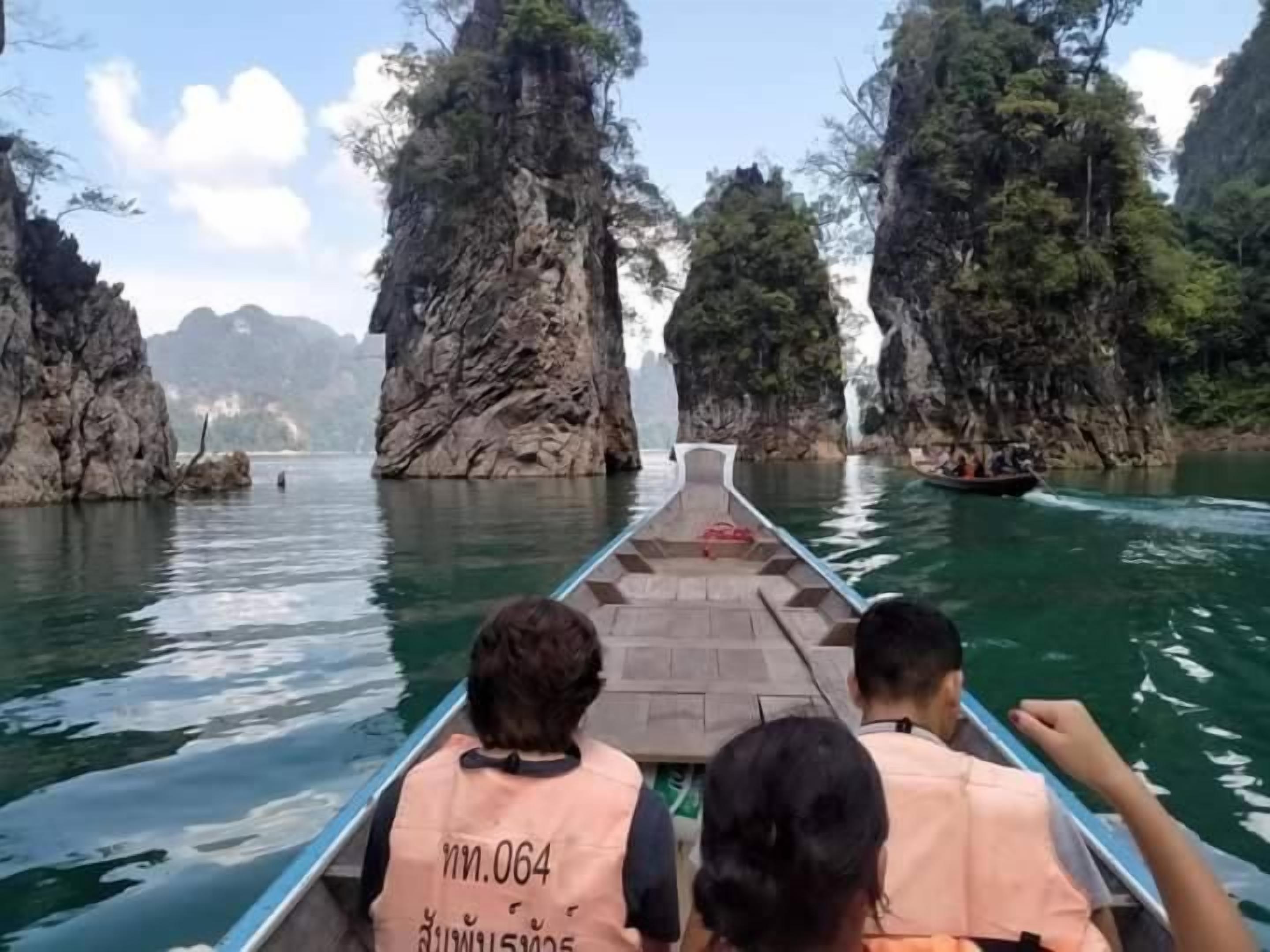 A boat ride through a narrow waterway flanked by rocky cliffs.