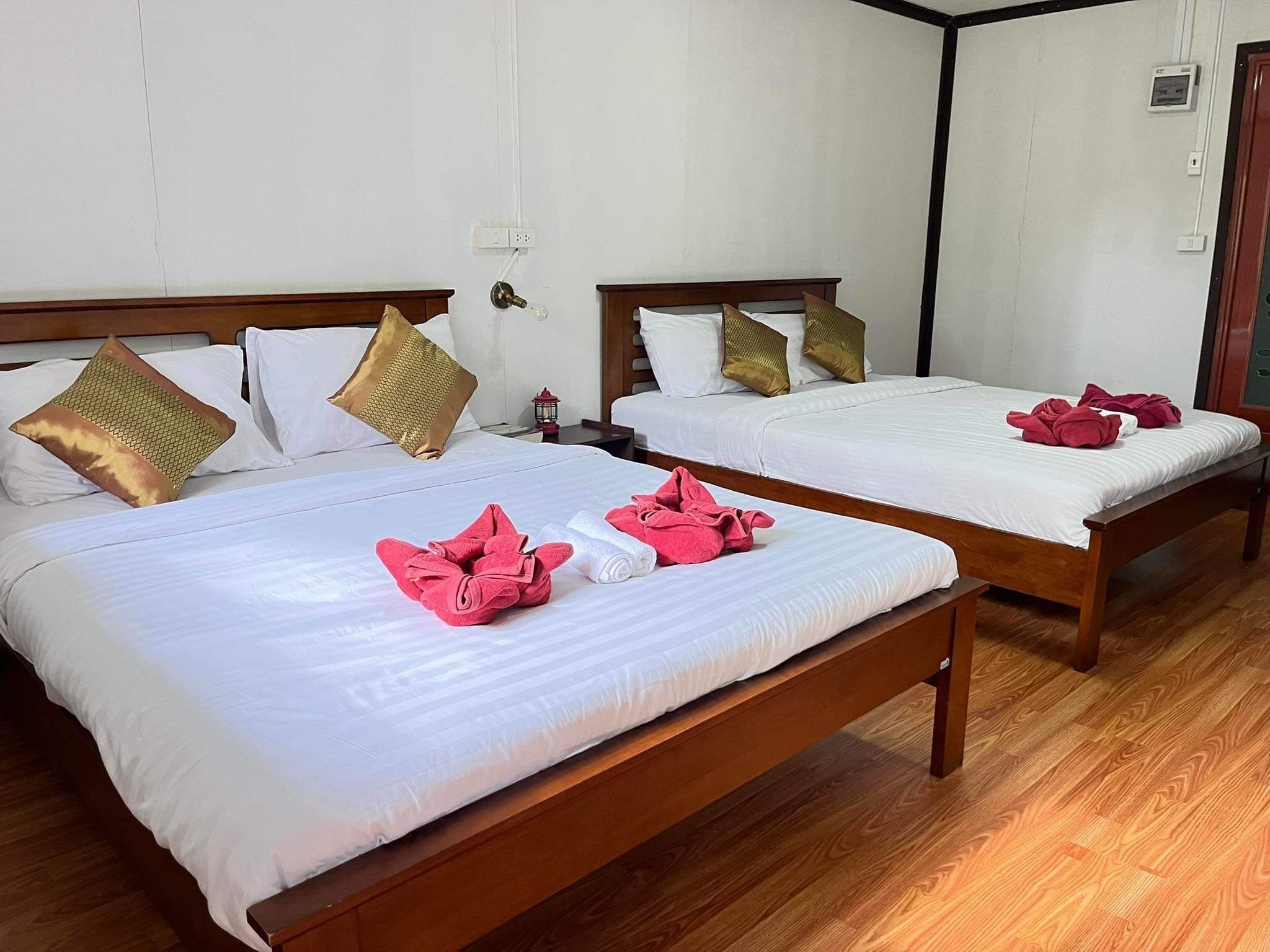 A hotel room with two beds, each with white linens and decorative pillows.