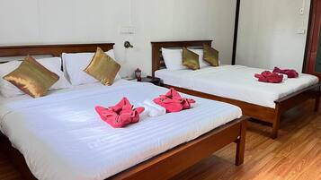 A hotel room with two beds, each with white linens and decorative pillows.