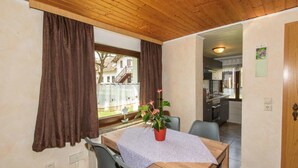A dining area with a wooden table, chairs, and a potted plant. - Ferienhof Bohg (Burg (Spreewald))