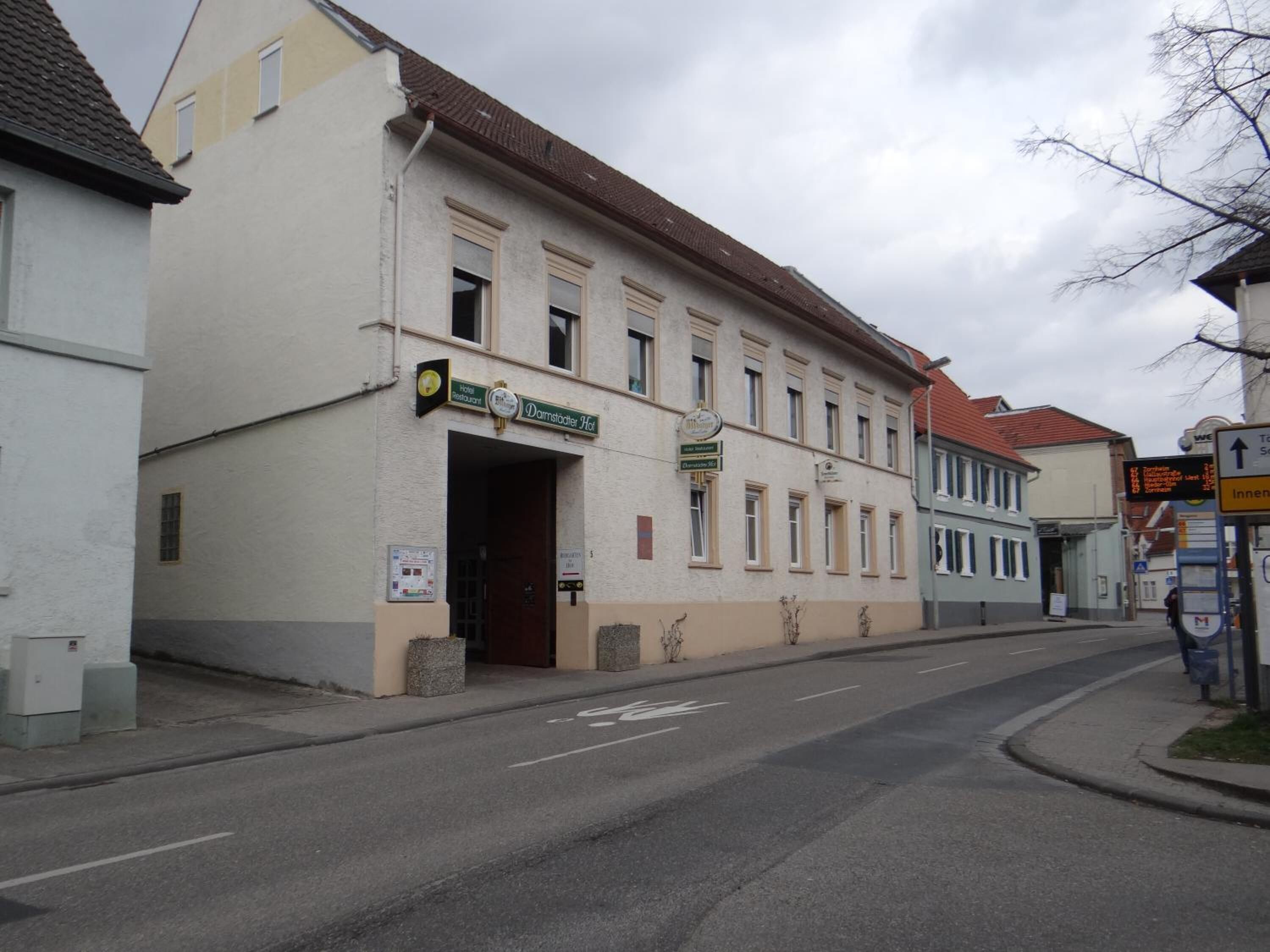A two-story building with a sign for 'Hotel Restaurant' and 'Dammstädter Hof' on the ground floor.