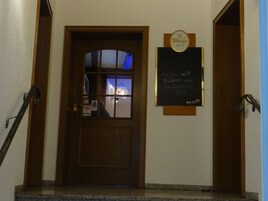 Una puerta de madera con un panel de vidrio, un letrero que dice 'Billburger' y una pizarra con texto.