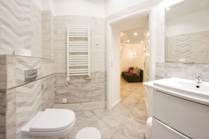 A modern bathroom with a toilet, a sink, and a shower area.