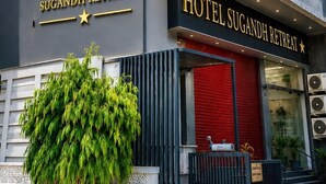Hotel amb façana moderna, un logotip solar destacat i una porta d'entrada vermella.