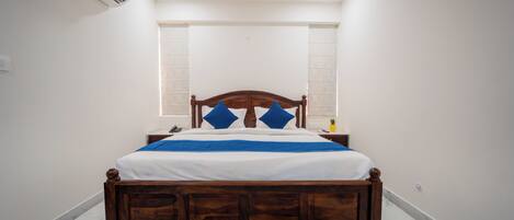 A bedroom with a wooden bed, white walls, and a marble floor.