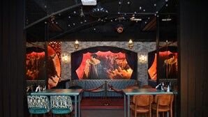Un restaurante con escenario, asientos de bar y un fondo de pared de ladrillo.