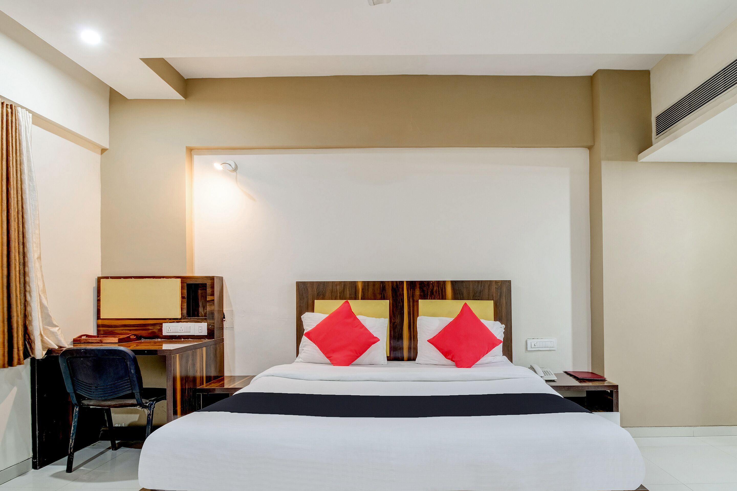Una habitación de hotel con una cama grande, un escritorio y una silla.