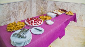 Uma mesa de buffet com diversos alimentos e utensílios.