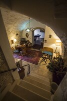 Una escalera conduce a una sala de estar con una mesa de comedor, sillas y un televisor.