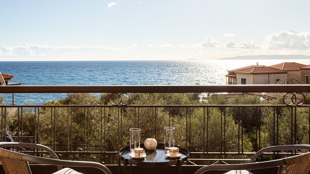 Ein Balkon mit Tisch für zwei Personen, mit Blick auf die Küste.