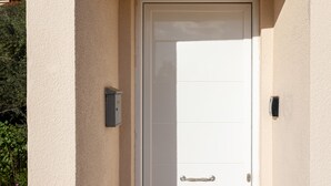 Eine weiße Tür mit Griff und einem an der Wand daneben angebrachten Sicherheitsschrank.