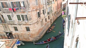A narrow canal with gondolas, historic buildings with balconies, and a clear view of the waterway. - Canale - WR Apartments (Venice)