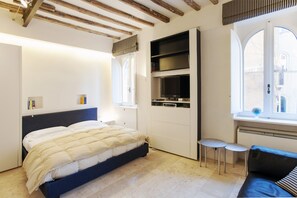 A bedroom with a bed, a wardrobe, a small table, and a window. - Oro - WR Apartments near Castel Sant'Angelo (Rome)