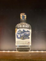Una botella de Whitby Gin sobre una superficie de madera.