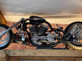 Una motocicleta con motor y sistema de escape a la vista, apoyada sobre un caballete.