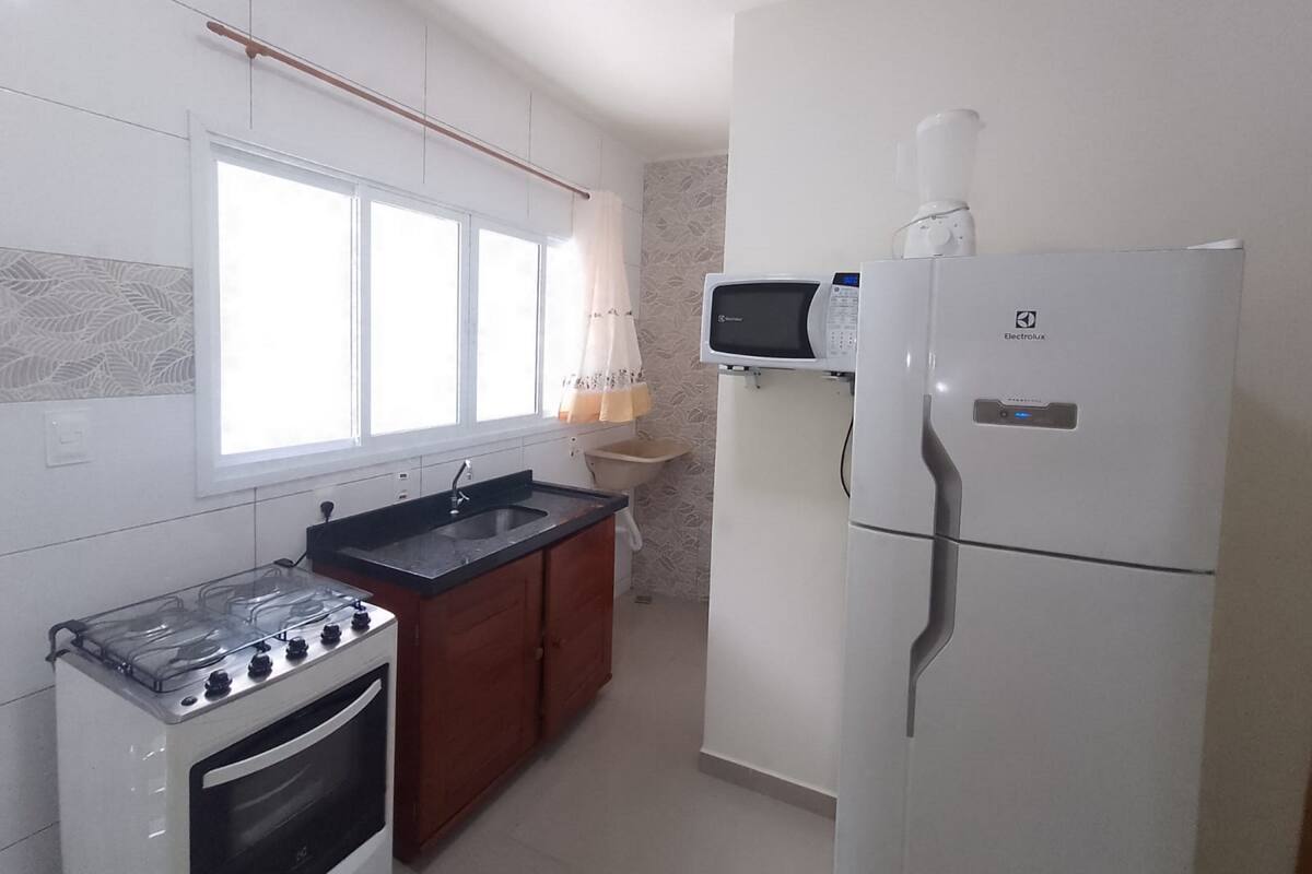 Uma cozinha equipada com fogão, forno, micro-ondas e geladeira.