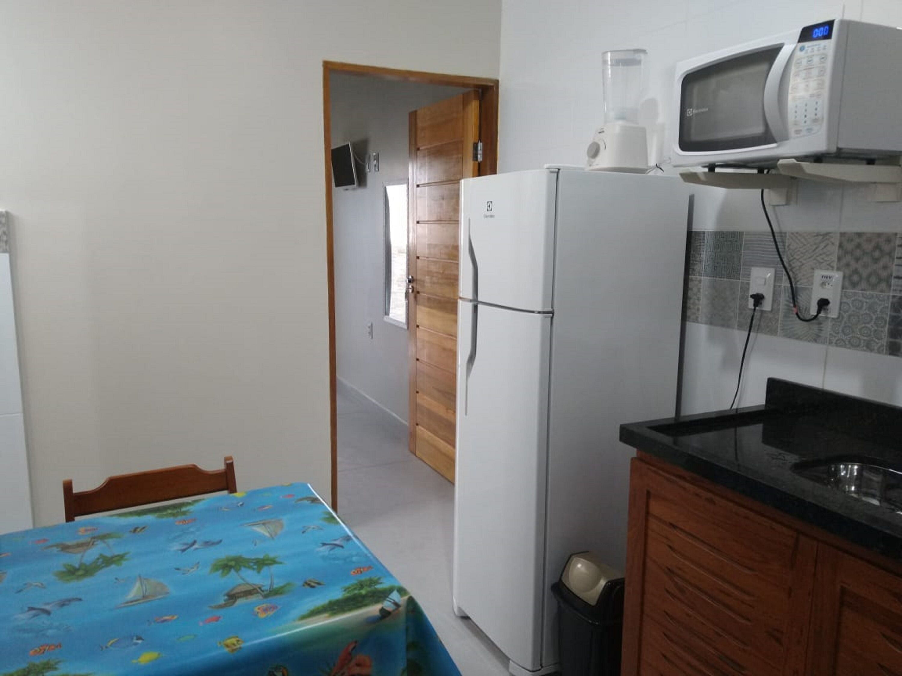 A compact kitchen with a refrigerator, microwave, and a small sink.