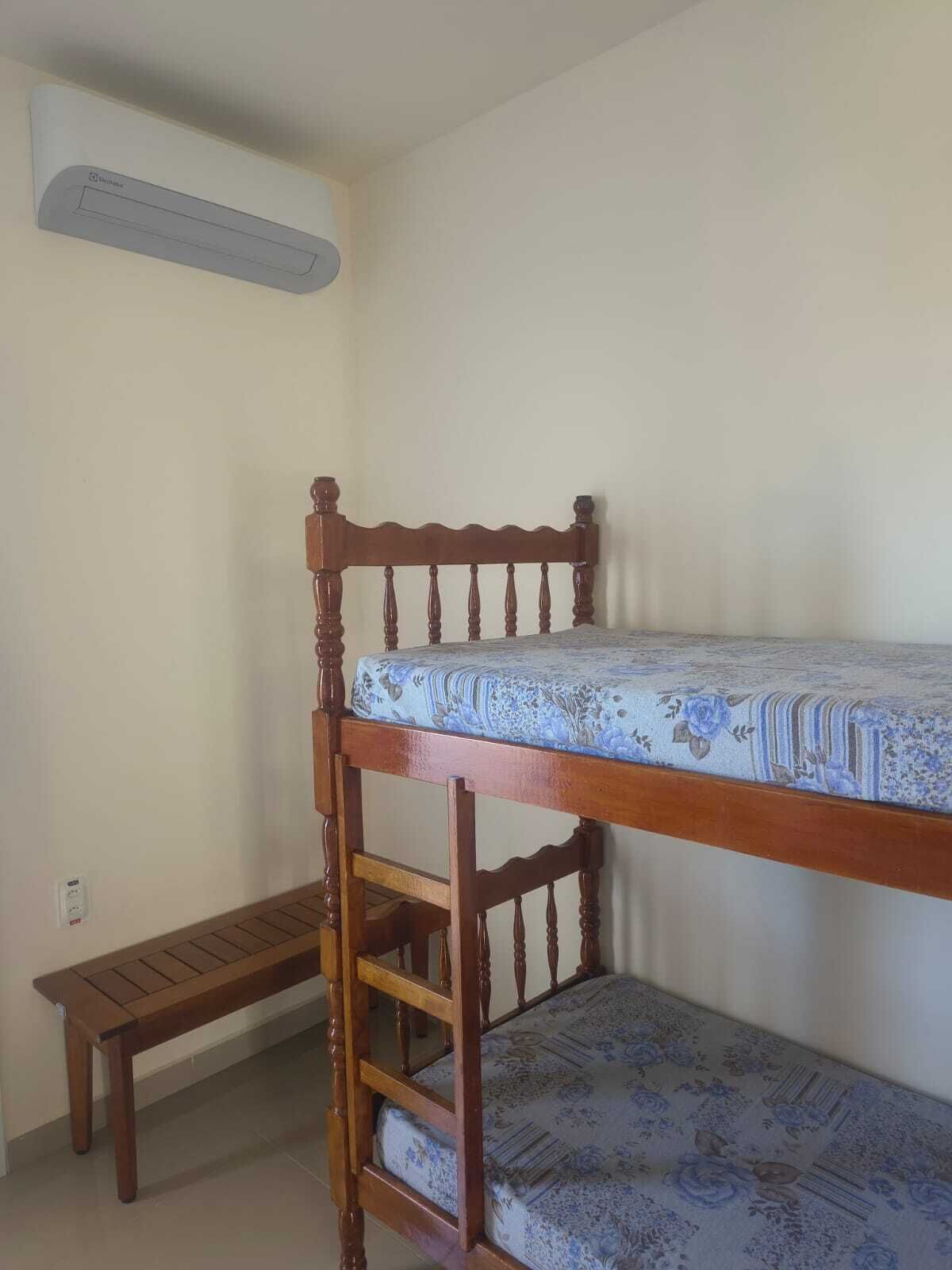 A bunk bed with a mattress and a wooden ladder.