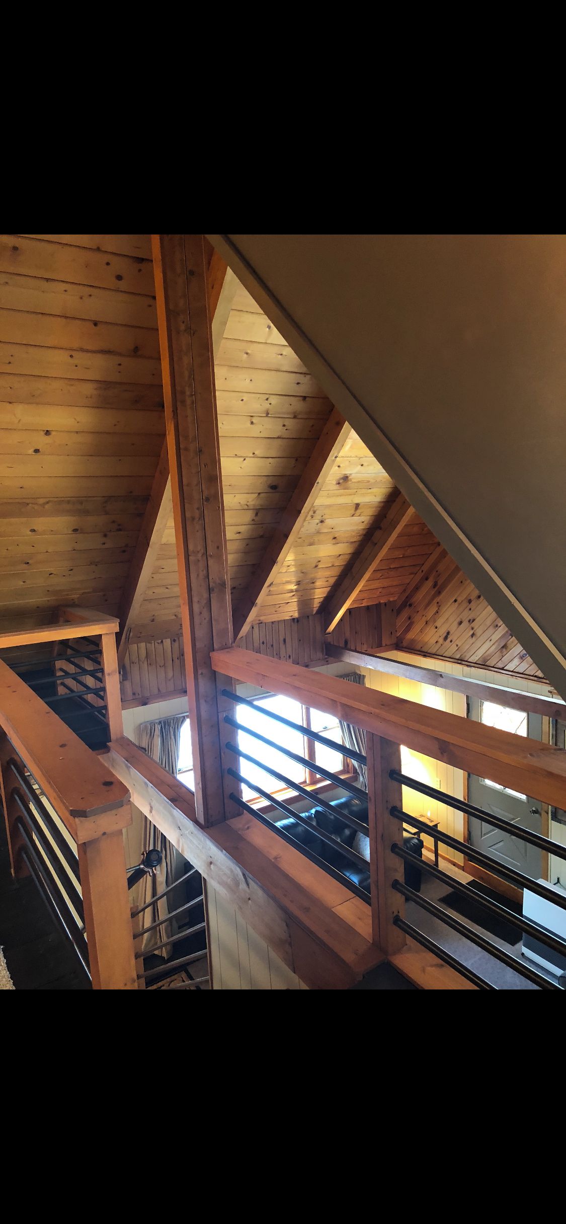 A wooden interior with a sloped ceiling and a staircase.