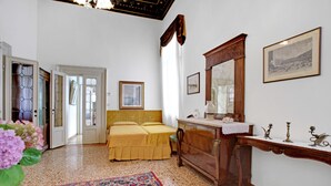 A room with a bed, a dresser, a mirror, and a rug. - Testa - WR Apartments (Venice)