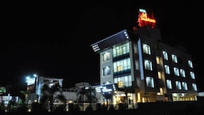 Un hotel de diseño moderno, con varios pisos y ventanas iluminadas.