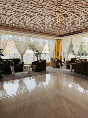 A spacious lobby with a geometric ceiling design, large windows with sheer curtains, and a reflective floor. - AL Muhaidb Residence Abha - Economic (Abha)