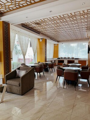 A hotel lobby with a dining area, multiple seating arrangements, and a decorative ceiling. - AL Muhaidb Residence Abha - Economic (Abha)