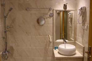 A bathroom with a shower, a sink, a mirror, and a hairdryer. - AL Muhaidb Residence Abha - Economic (Abha)