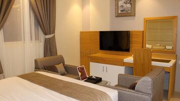 A hotel room with a bed, a desk, a television, and a mirror.