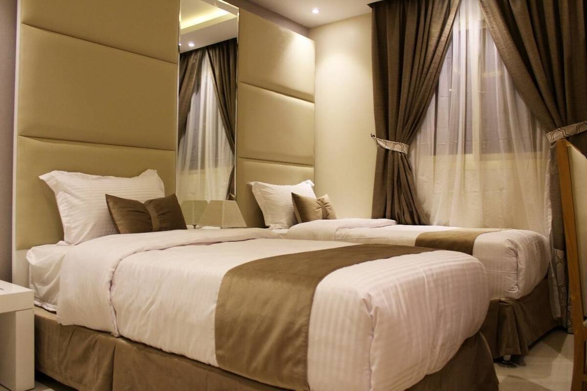 Ein Hotelzimmer mit einem großen Bett, einem Nachttisch und einem Spiegel.