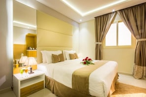 A hotel room with a bed, bedside table, lamp, and a window with curtains. - AL Muhaidb Residence Abha - Economic (Abha)
