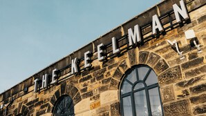 Un bâtiment en pierre sur lequel on peut lire l’inscription « THE KEELMAN » au-dessus d’une fenêtre en arc de cercle.