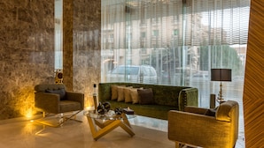 A modern living room with a green sofa, two armchairs, a glass coffee table, and a lamp. - Ewaa Express Hotel - Al hamra (Jeddah)