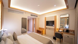 A hotel room with a large bed, a desk, a chair, a TV, and a mirror. - Smana Hotel Al Raffa (Dubai)
