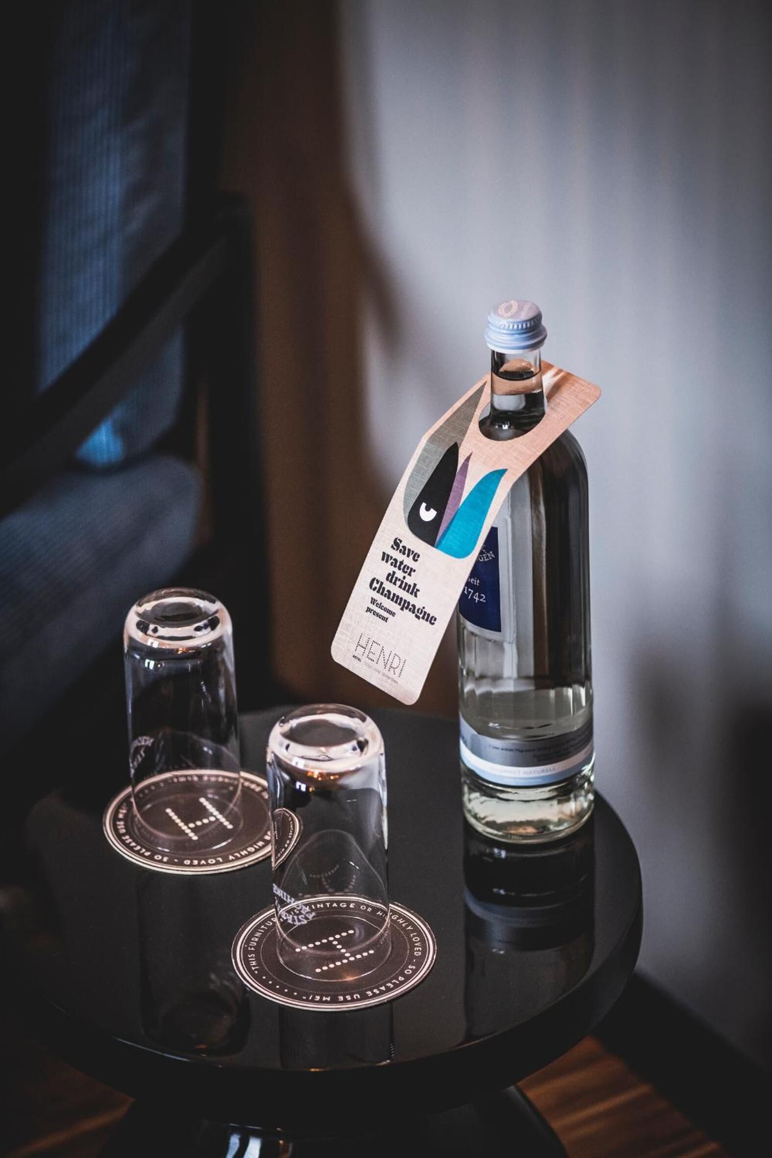 Eine Champagnerflasche mit einem Anhänger auf einem schwarzen Tisch.