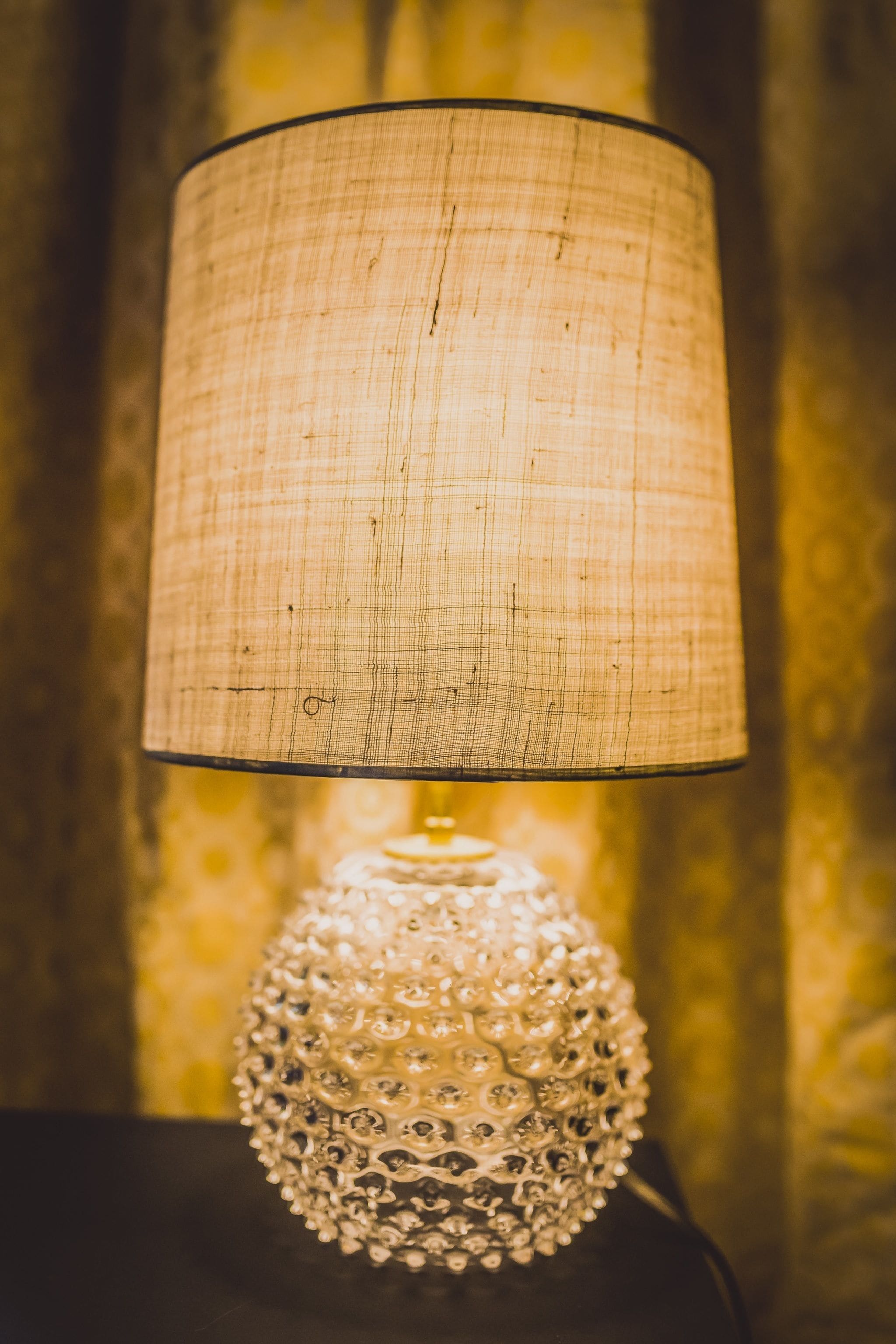 A lamp with a textured shade and a decorative base.