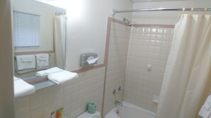 Uma casa de banho com cabine de duche envidraçada, sanita e lavatório com espelho.