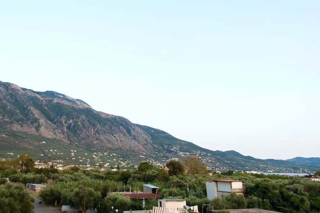 Un paysage montagneux parsemé de bâtiments et de végétation.
