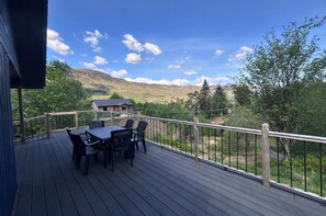 A deck with a table and chairs, overlooking a mountainous landscape. - Gamekeeper, 3 bedroom, 4 star, sleeps up to 6 (Crianlarich)