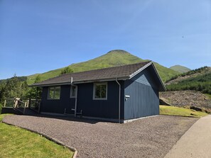 Un petit bâtiment d’un seul étage, doté d’un toit en pente, situé sur une allée de gravier avec une zone herbeuse en premier plan.