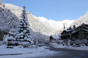 Un pueblo cubierto de nieve en la montaña, con un edificio de madera que parece ser un restaurante.
