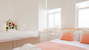 Une chambre d’hôtel avec un lit, une table de chevet et une fenêtre.