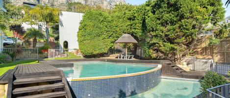 Een buitenzwembad, parasols voor strand/zwembad