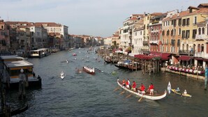 A canal with boats, historic buildings, and a row of restaurants along the water. - Venice Agostino Guesthouse (Mestre)