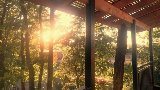 A wooden pergola structure with a view of a forested area. - Des Branches & Vous (Chateauneuf-sur-Isere)