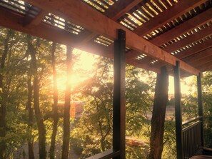 A wooden pergola structure with a view of a forested area. - Des Branches & Vous (Chateauneuf-sur-Isere)
