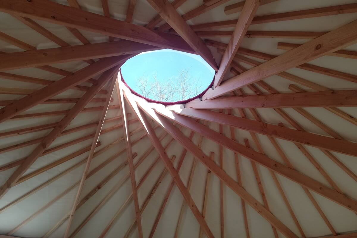 A wooden ceiling structure with a skylight.