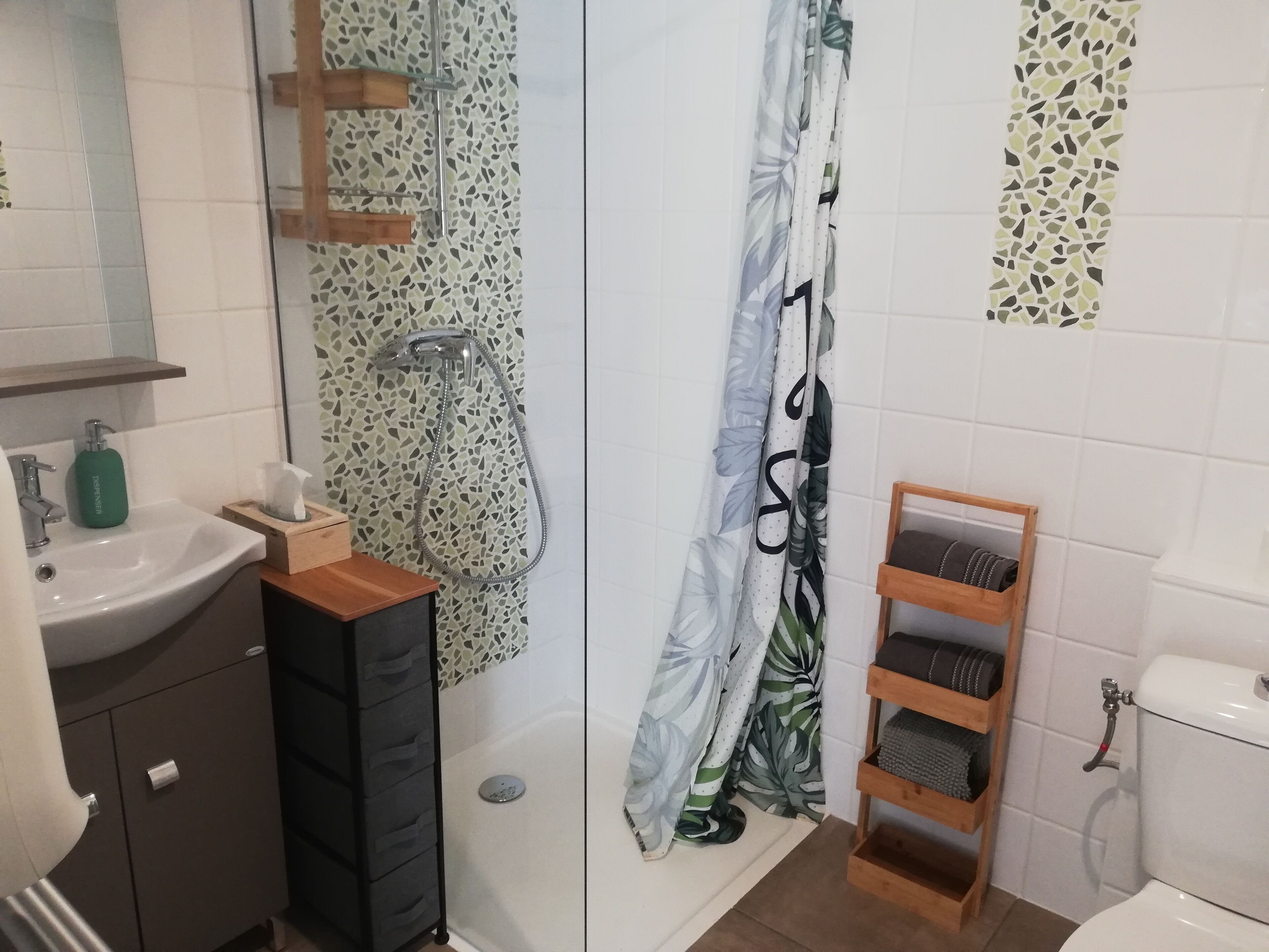 Ein Badezimmer mit Dusche, Toilette, Waschbecken und Stauraumschränken.