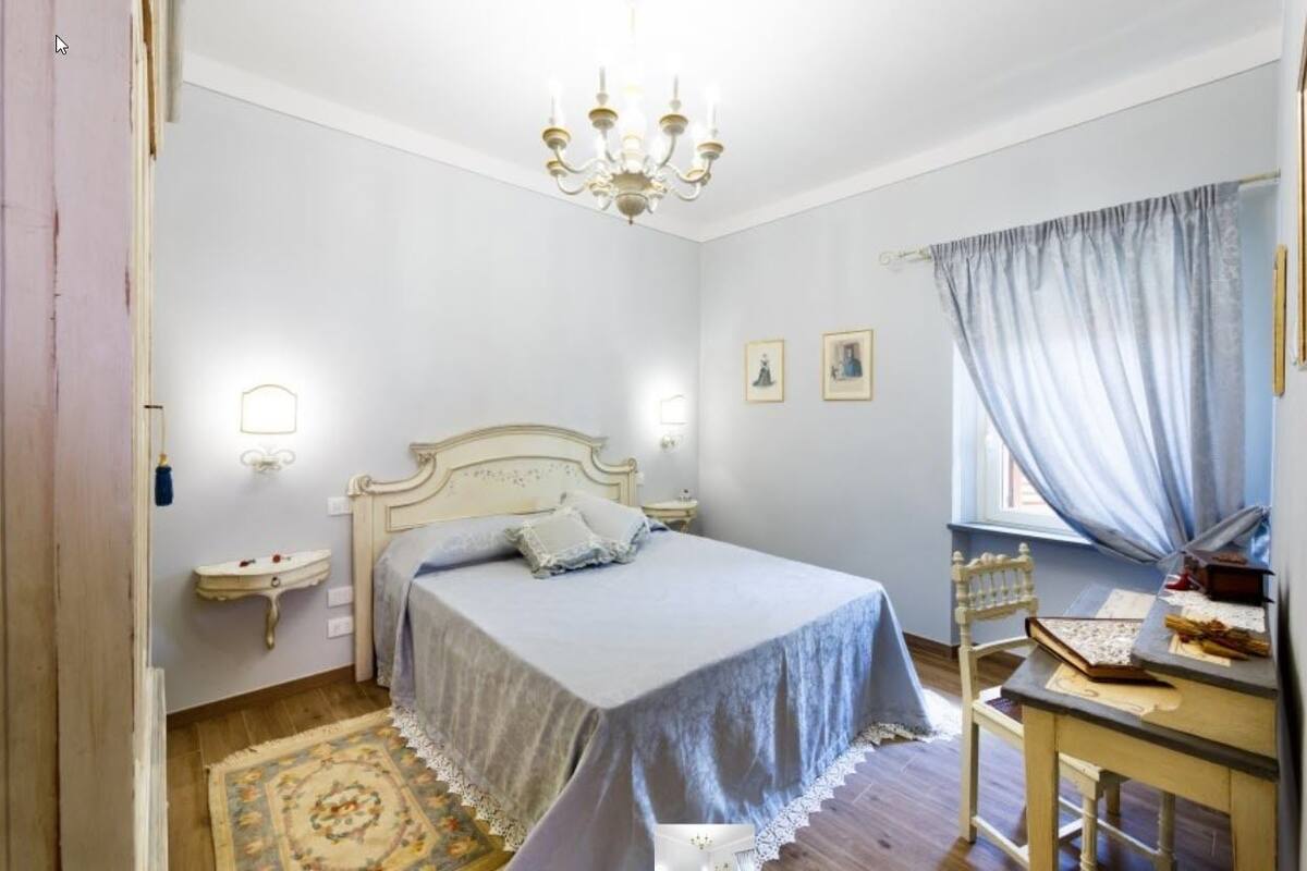 Une chambre à coucher comprenant un lit, une table de chevet et un bureau avec une chaise.