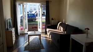 A living room with a sofa, a coffee table, and a TV on a wooden cabinet. - 1 Sterling Court City Center (Canterbury)
